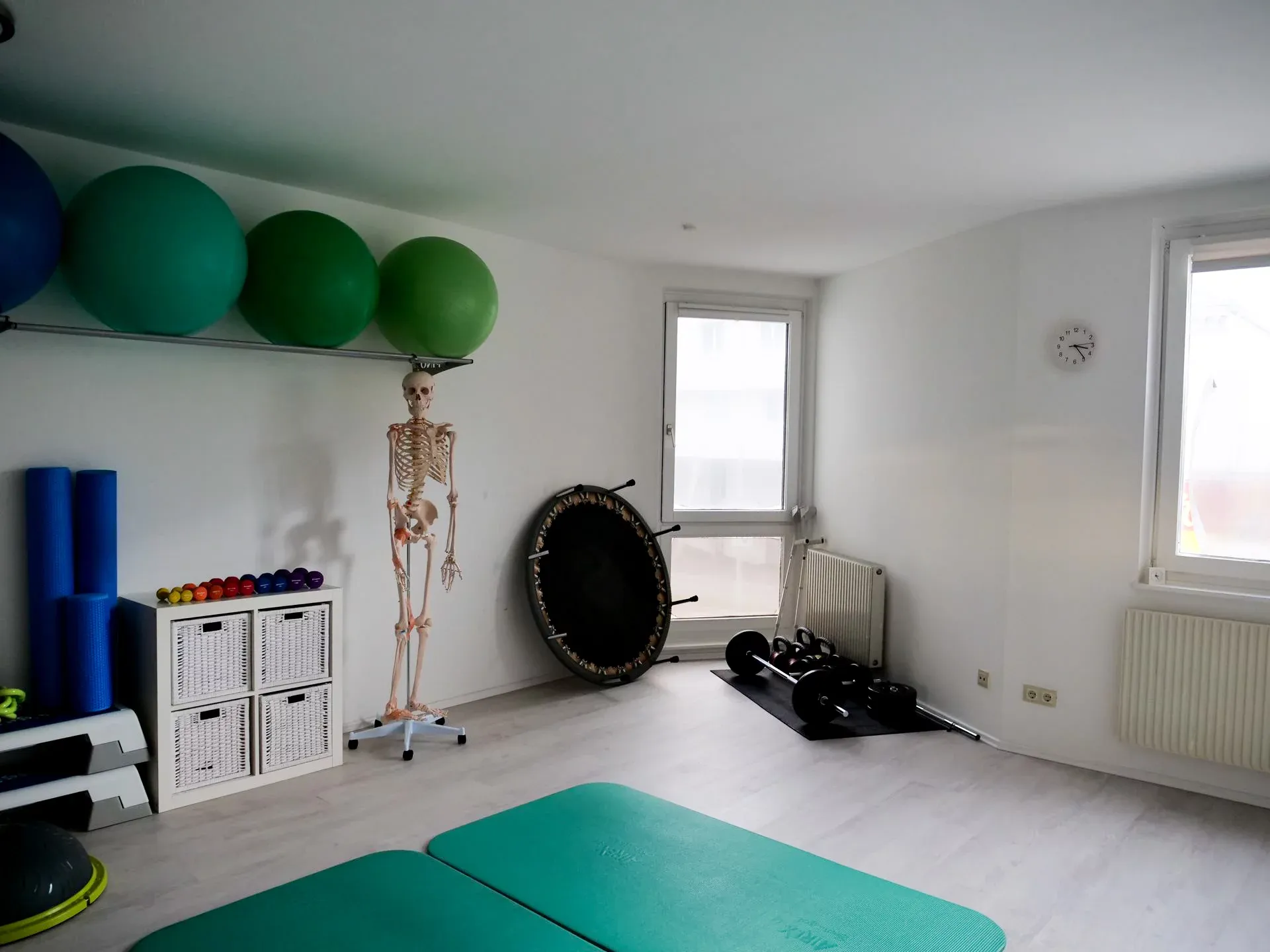 Trainingsraum mit Gymnastikbällen, Skelettmodell und Geräten